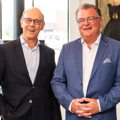 Beyond the Handshake Warren Salvador_2026-07-21-2_Page_10_Image_0002 - Executive Search, Recruitment and Talent Management - The ExeQfind Group Two smiling men in business attire standing side by side indoors, posing for a photo at a professional event.