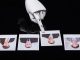 Robotic hand with extended finger points at a row of four Polaroid photos of businesspeople on a dark surface.